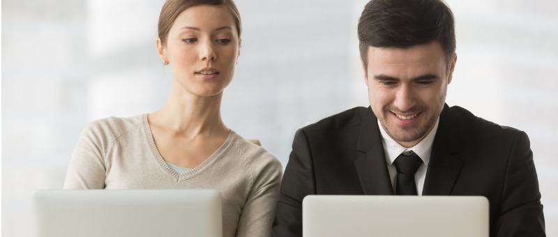 Mujer copiando las respuestas de su compañero de trabajo desde su laptop